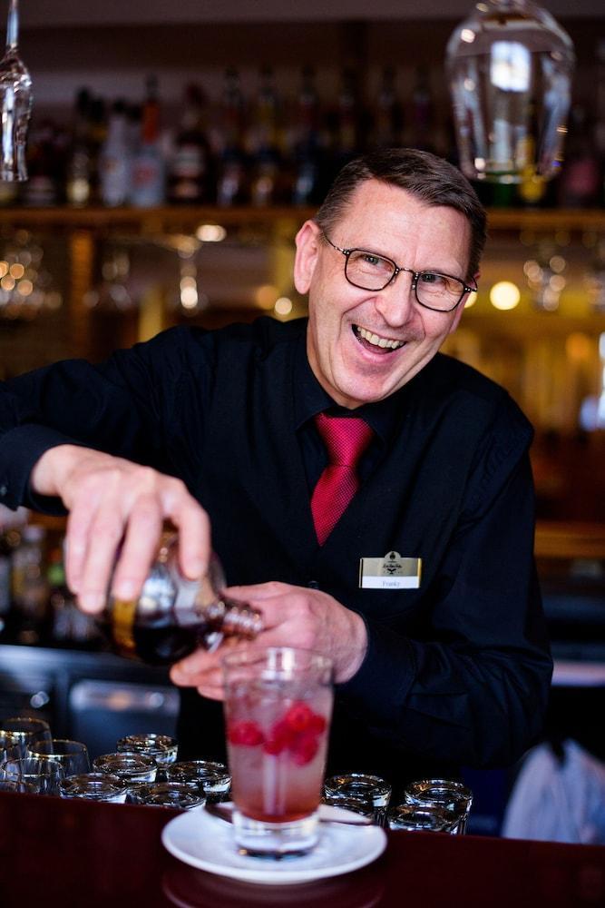 랜드하우스 주 덴 로덴 포어렌 호텔 일젠부르크 외부 사진 A bartender at work